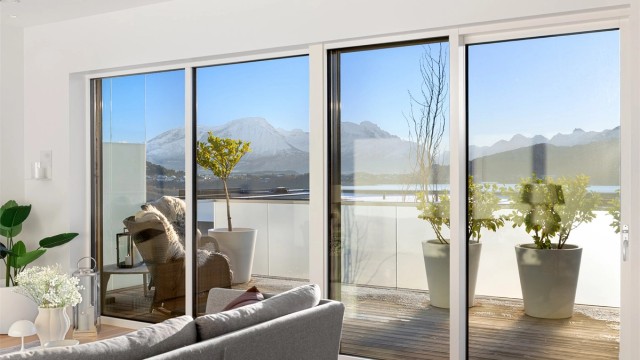 Store skyvedørsfronter på stue med utgang til balkong