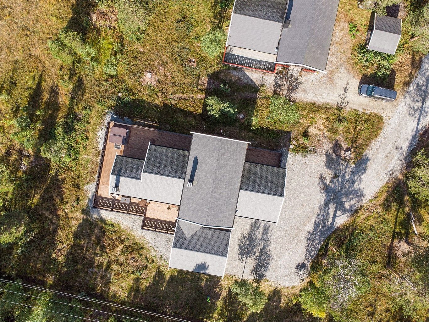 Tomten er opparbeidet med romslig terrasse og gruset innkjørsel fram til garasjen.