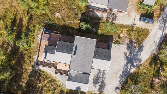 Tomten er opparbeidet med romslig terrasse og gruset innkjørsel fram til garasjen.