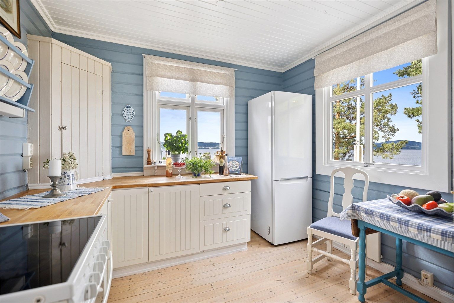 Kjøkkenet er lyst og sjarmerende med profilerte fronter og heltre benkeplate - alt i  klassisk hyttestil