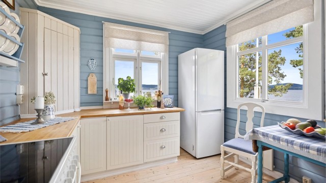 Kjøkkenet er lyst og sjarmerende med profilerte fronter og heltre benkeplate - alt i klassisk hyttestil