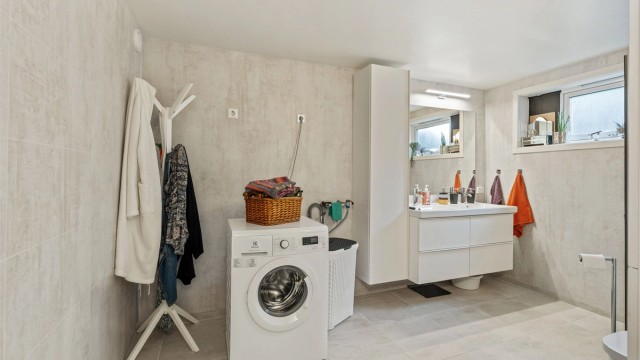 Badet har gulvvarme og praktisk opplegg for vaskemaskin.