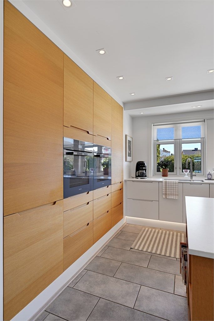 Rikelig med skapplass i takhøye skap med glatte fronter.