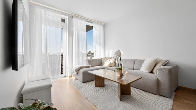 Lys stue med store vindusflater som gir mye lys.