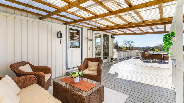 Med kjøkkenet rett innenfor kan måltidene enkelt å tas med utendørs. Skjermende overbygg gjør det mulig å sitte ute selv om sommerværet ikke er på sitt aller beste.