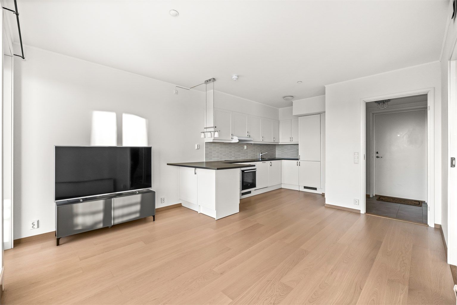 Stuen har en åpen og sosial løsning mot kjøkkenet.