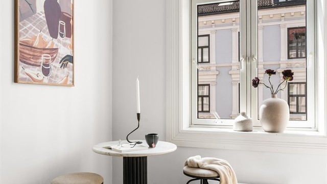 Et naturlig sted for morgenkaffen, med dagslys fra vinduet og utsyn mot den klassiske bygårdsbebyggelsen.