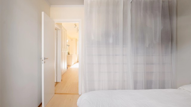 Bak de luftige gardinene finner du et vell av oppbevaring, og rommet flyter sømløst videre inn i resten av boligen – alt er mykt og gjennomtenkt her hjemme!