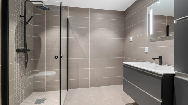 Badet inneholder blant annet servantskap, speil med innebygd lys, vegghengt toalett, opplegg for vaskemaskin og downlights i himling.