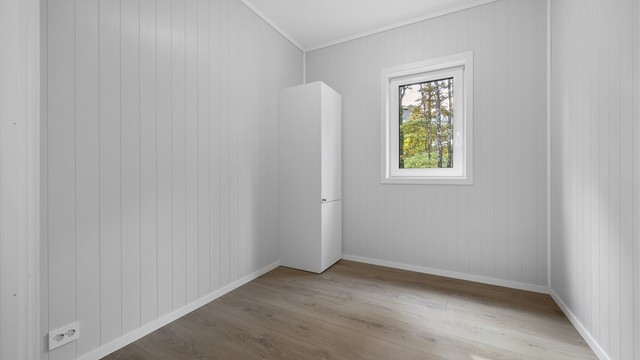 Soverom med plass til seng og garderobeskap, vendt mot grønne omgivelser.