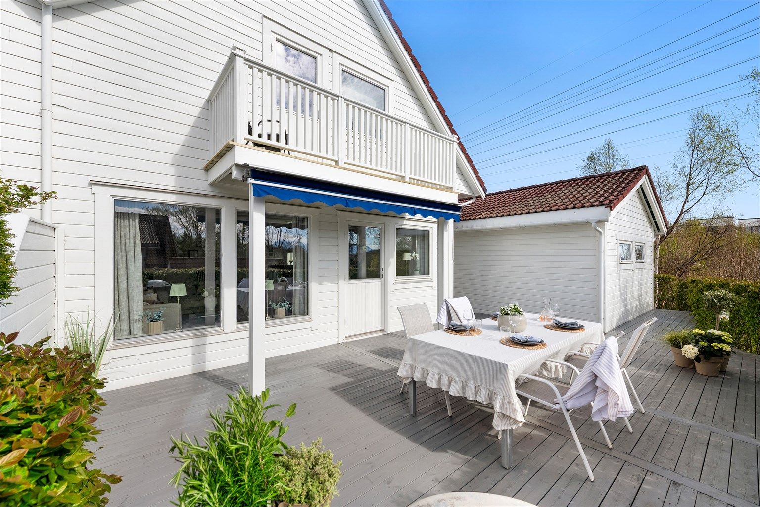 Stor skjermet markterrasse mot syd med hekk og levegg mot nabo. Stor markterrasse som gir ly for vær 