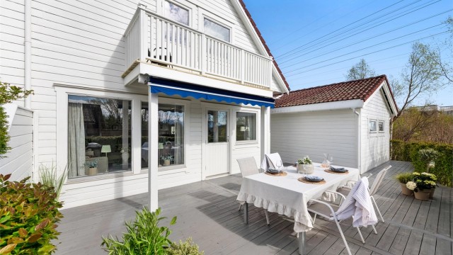 Stor skjermet markterrasse mot syd med hekk og levegg mot nabo. Stor markterrasse som gir ly for vær