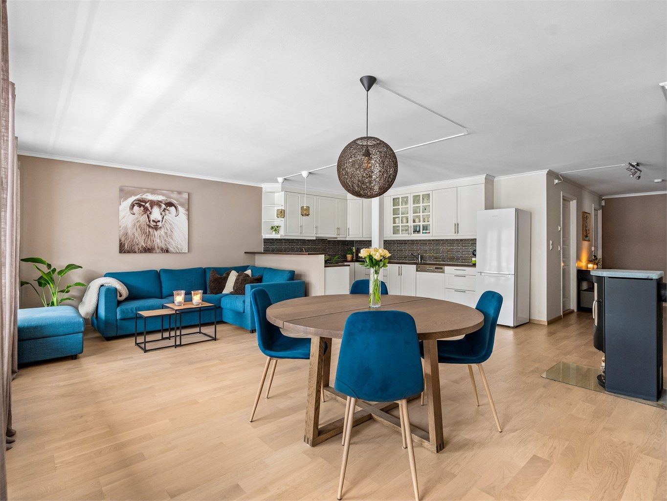 Den åpne løsningen mellom stue og kjøkken skaper en sosial og luftig atmosfære