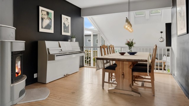 Spisestuen er et sentralt samlingspunkt i leiligheten, med tregulv og malte flater.