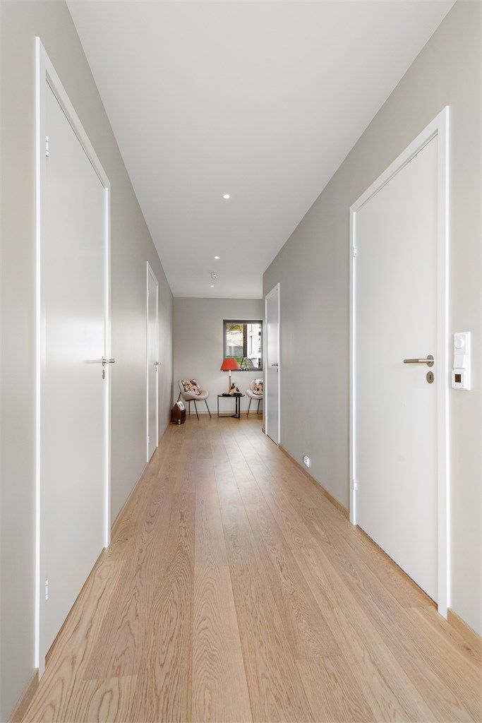 Gangen har downlights i taket og binder sammen alle rommene i leiligheten