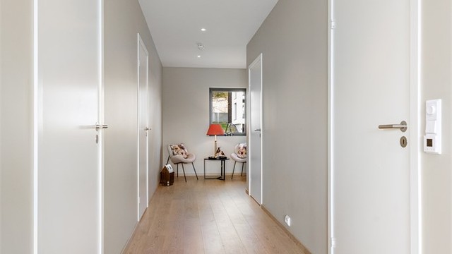 Gangen har downlights i taket og binder sammen alle rommene i leiligheten