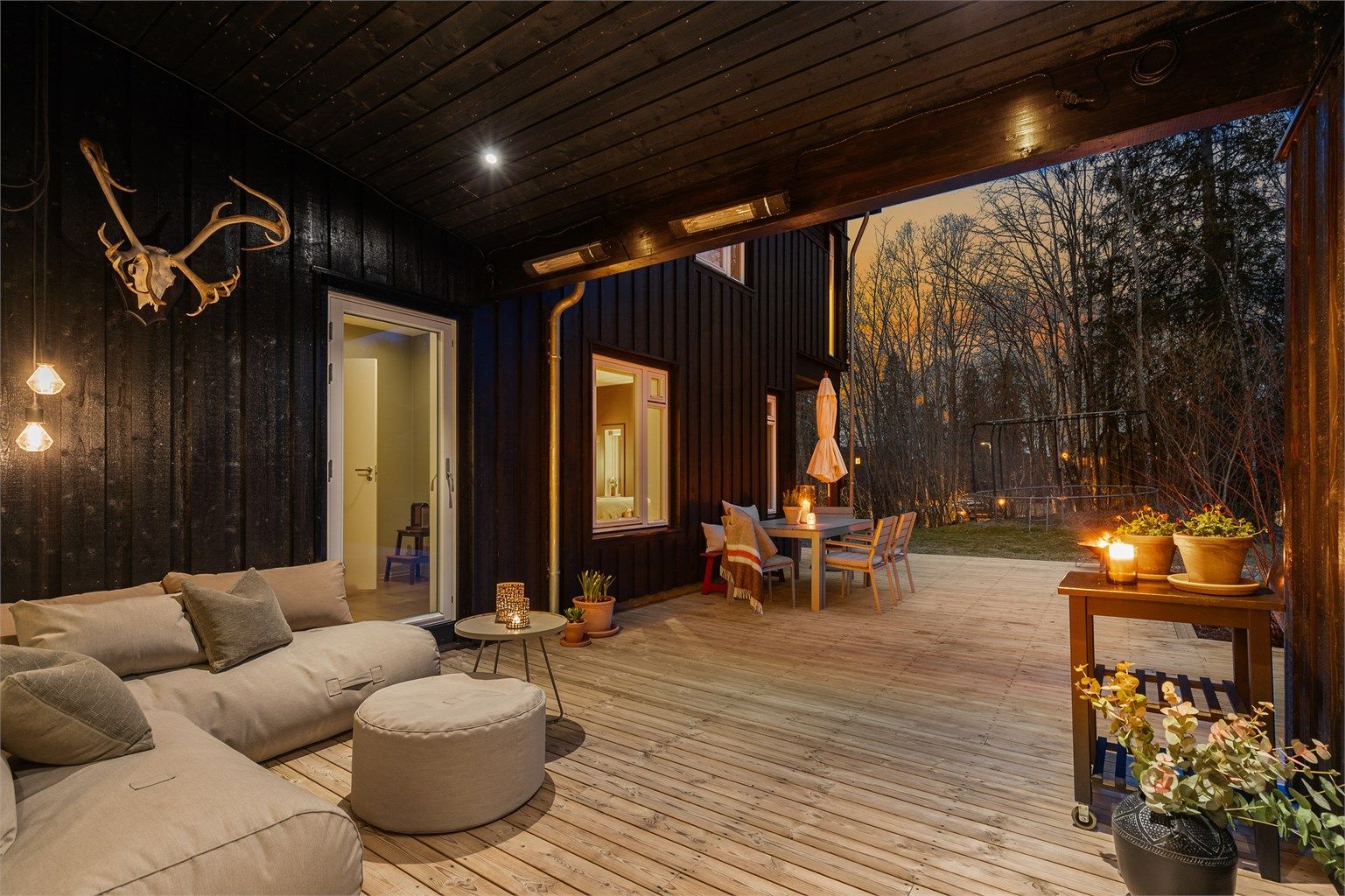 Koselig sitteplass under tak med utgang fra kjøkkenet og fra entreen/gangen.