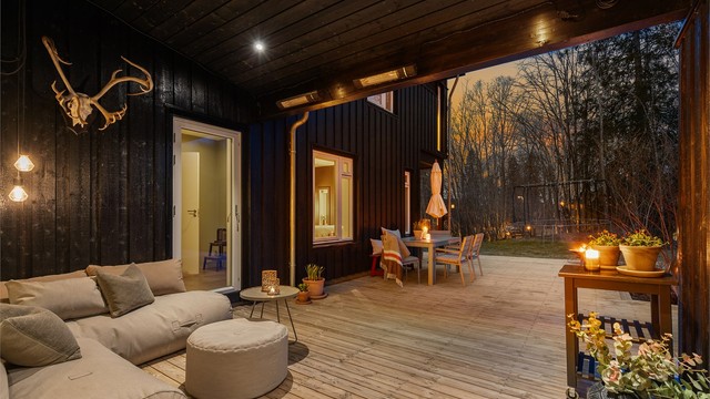 Koselig sitteplass under tak med utgang fra kjøkkenet og fra entreen/gangen.