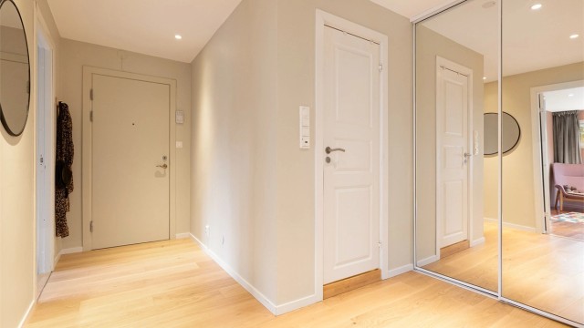 Skyvedørsgarderobe med speilfronter gir gode oppbevaringsmuligheter i gangen.