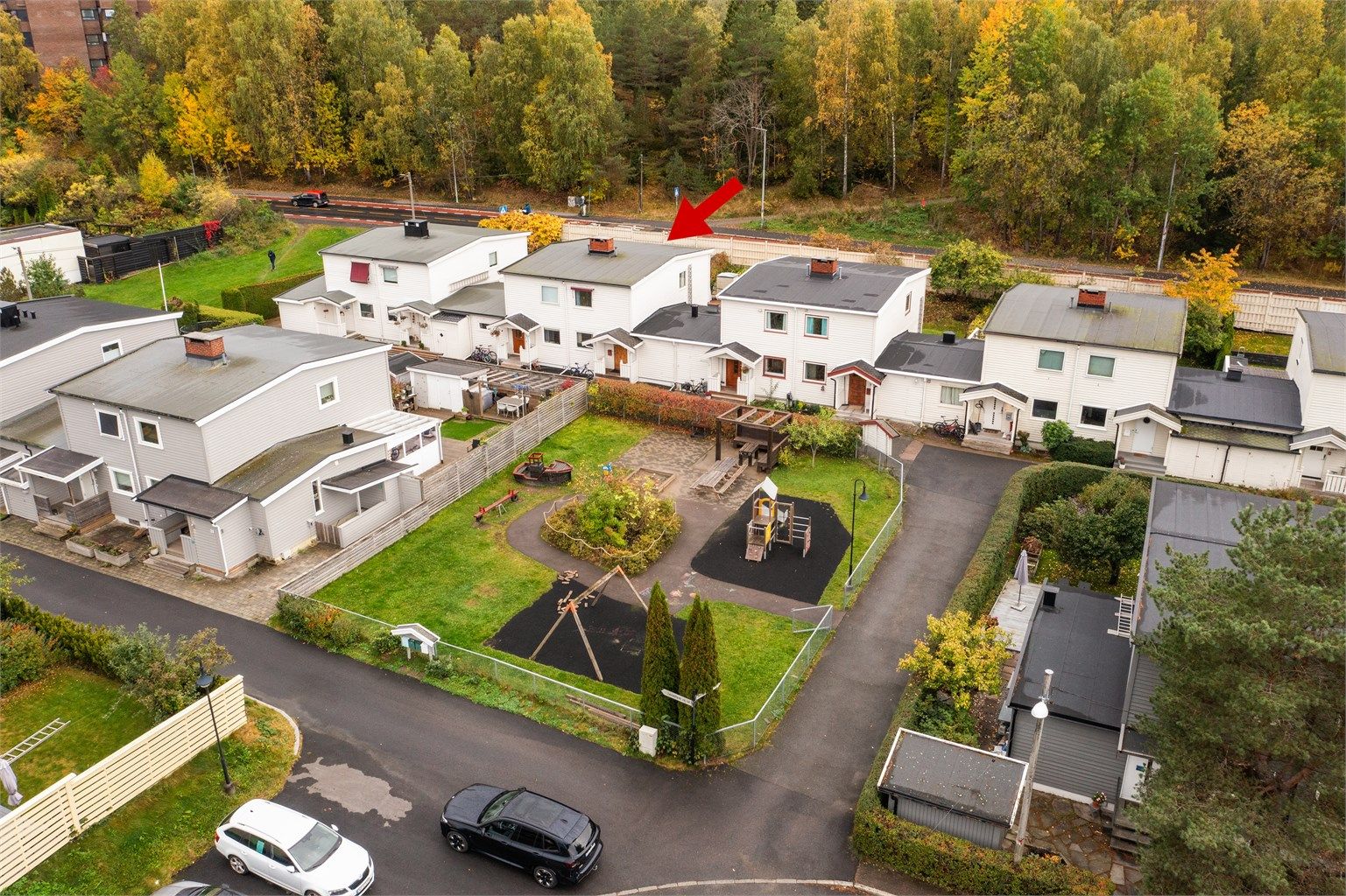 Skjermet fellesområde med lekeplass og sittebenker like utenfor inngangsdøren.