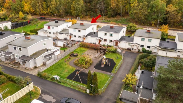 Skjermet fellesområde med lekeplass og sittebenker like utenfor inngangsdøren.