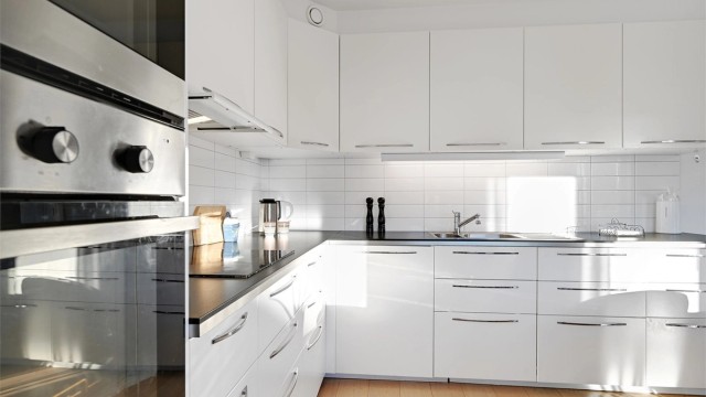 Kjøkkenet har innredning med glatte fronter. Benkeplaten er av laminat. Det er kjøl/fryseskap, oppvaskmaskin, induksjonstopp, mikrobølgeovn og stekeovn integrert i innredningen.