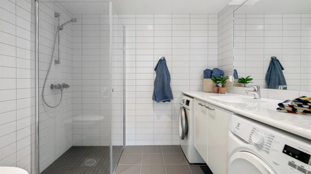 Pent, flislagt baderom med opplegg for vaskemaskin/tørketrommel