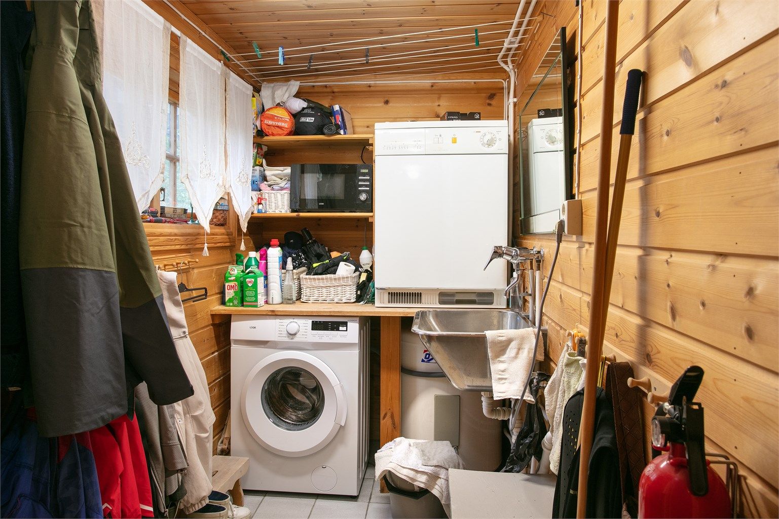 Praktisk vaskerom med flislagt gulv, varmekabler, opplegg for vaskemaskin og vaskekum.