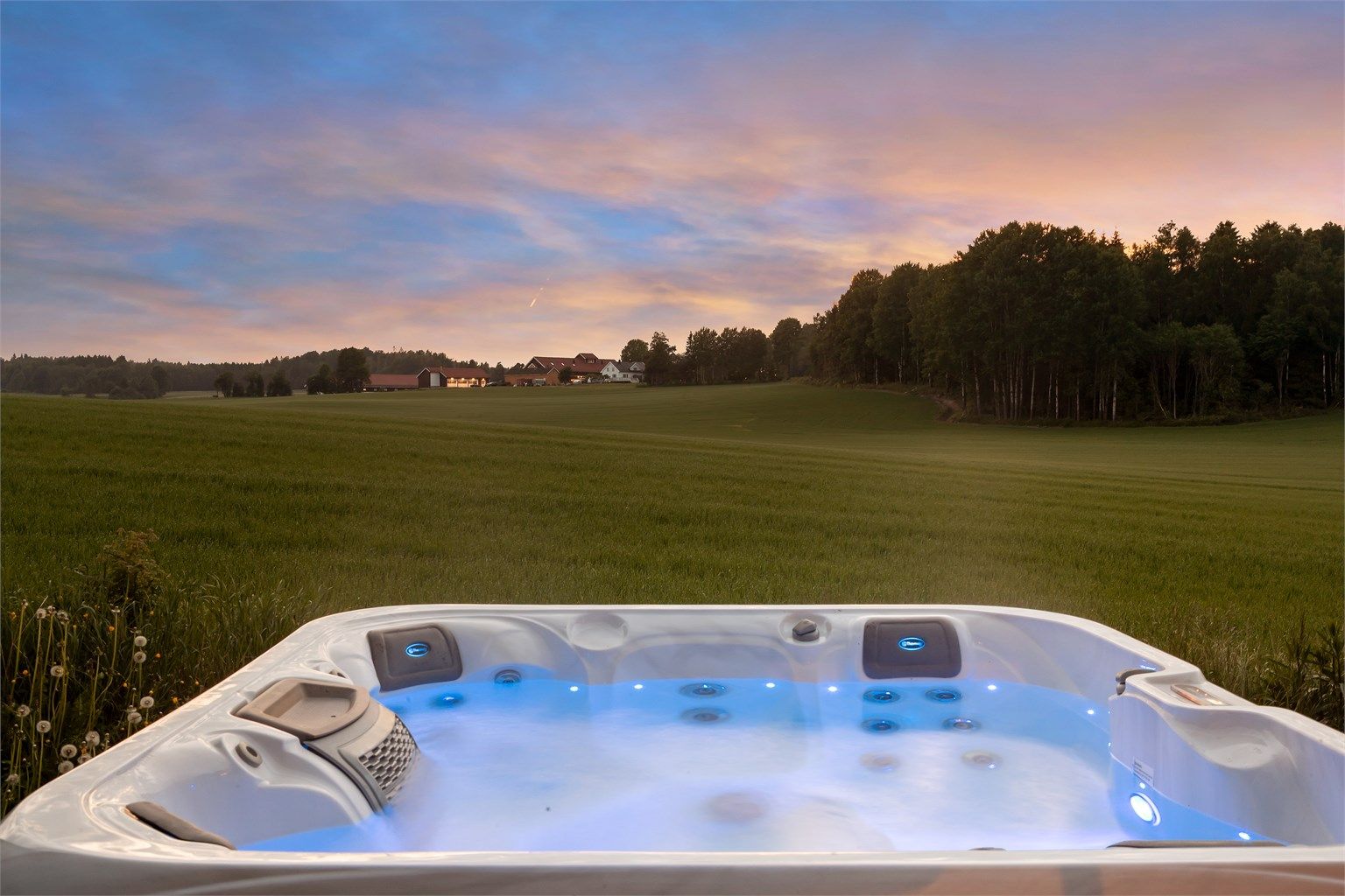 Utsikt fra terrassen mot det åpne kulturlandskapet. Jacuzzi medfølger salget. 