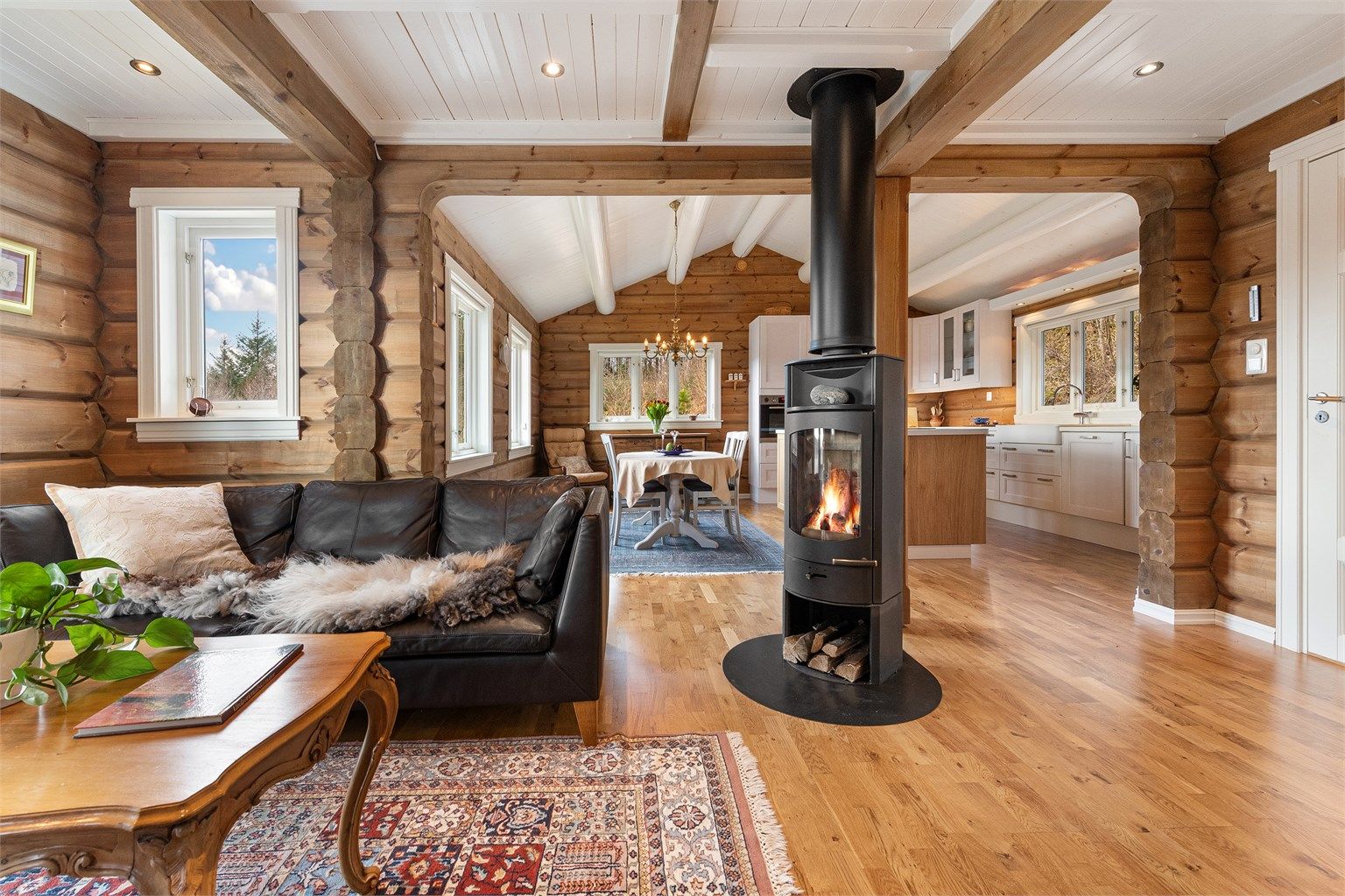 En sentralt plassert peisovn med glassdør skaper en lun atmosfære.