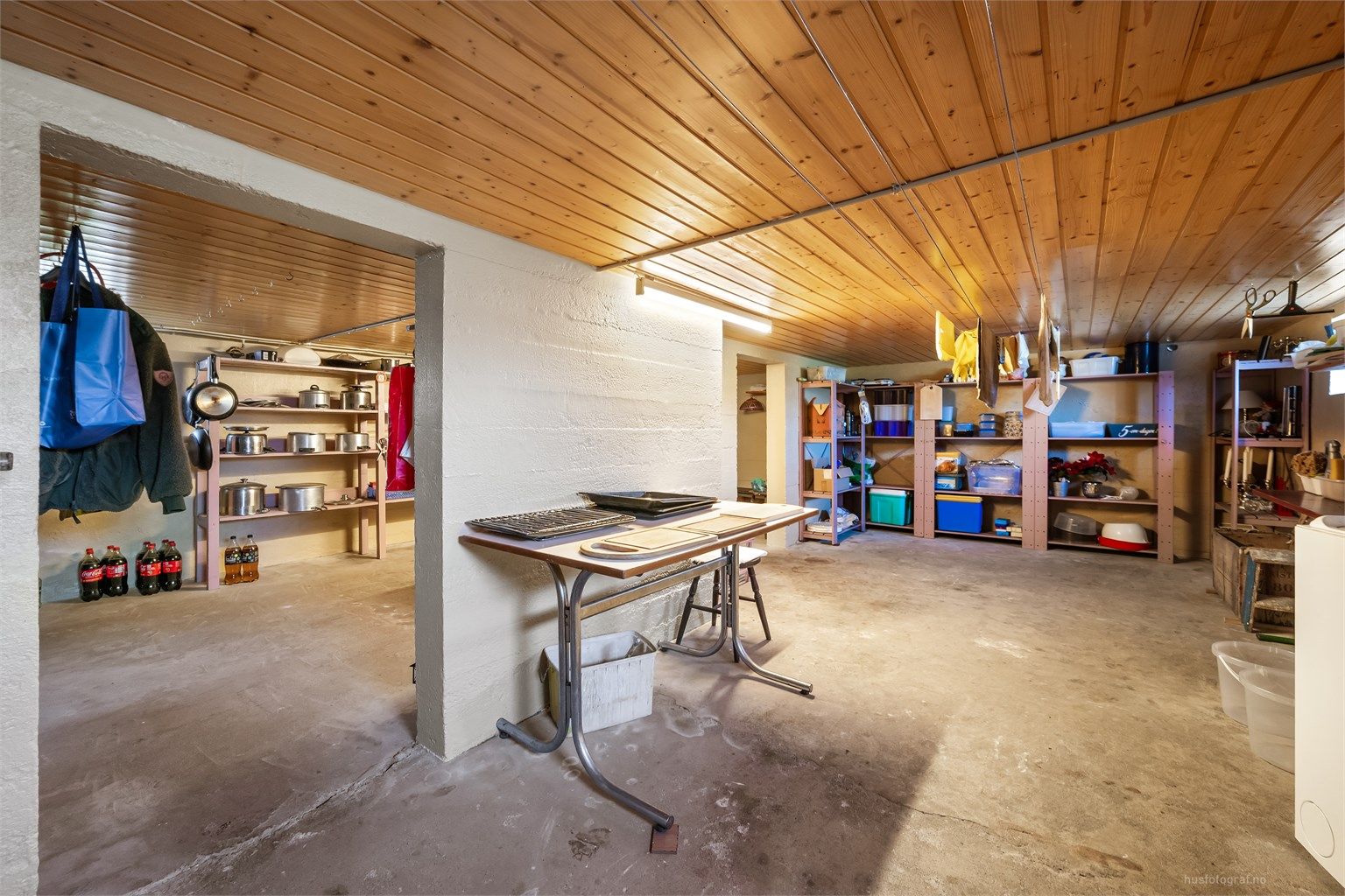Kjelleren har betonggulv og rikelig med lagringsplass.