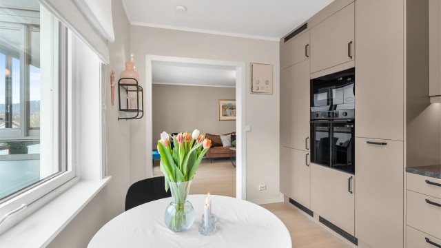 Fra kjøkkenet er det en åpen og sosial forbindelse til stuen, som gjør det enkelt å være sammen.