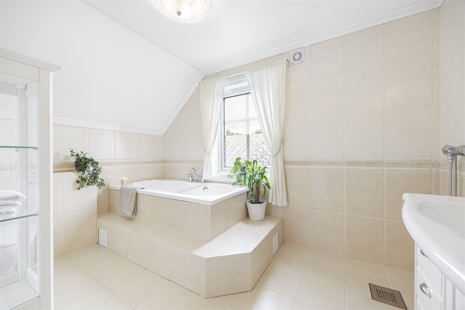 Badet i loftsetasjen er helfliset og utstyrt med et romslig, innebygd badekar.