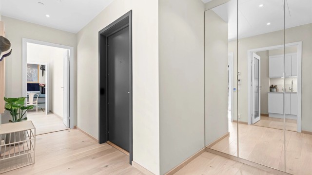 Gangen har en praktisk garderobe med speilfronter for oppbevaring