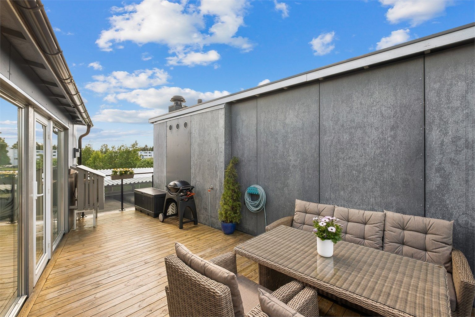 Takterrassen blir et naturlig samlingspunkt i sommerhalvåret, med god plass til både måltider, avslapning og hyggelige grillkvelder i solen.