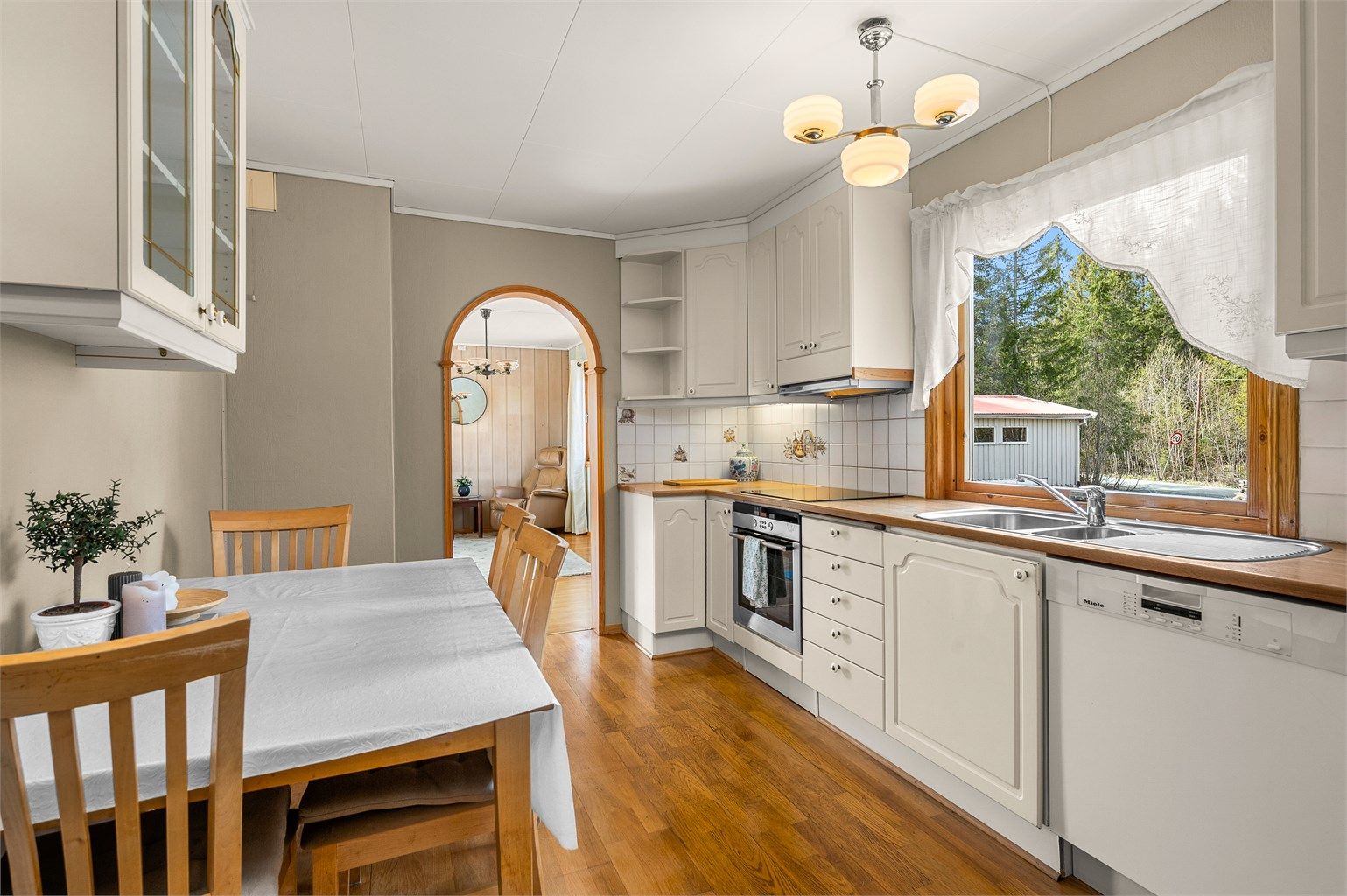 Kjøkkenet ligger naturlig tilbaketrukket fra stuen og er innredet med lyse slette fronter og laminert benkeplate. 