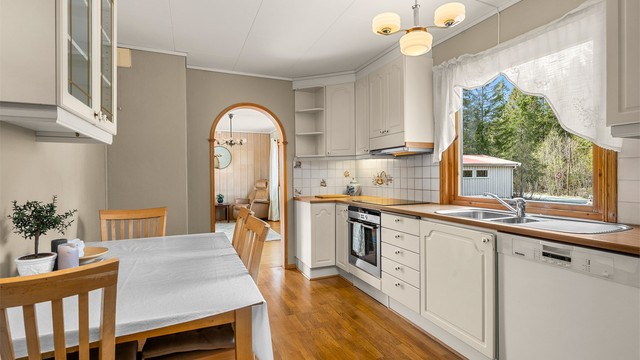 Kjøkkenet ligger naturlig tilbaketrukket fra stuen og er innredet med lyse slette fronter og laminert benkeplate.