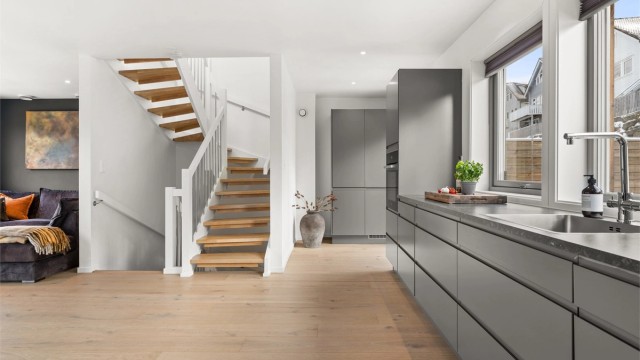 Den innvendige trappen i tre med metallrekkverk binder etasjene elegant sammen.