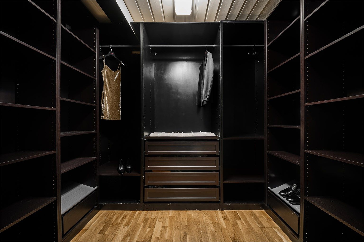 Bod mellom hovedsoverommet og badet er tatt i bruk som walk-in closet. Garderobeinnredningen gjør det lett å holde oversikt på klær og tilbehør.
