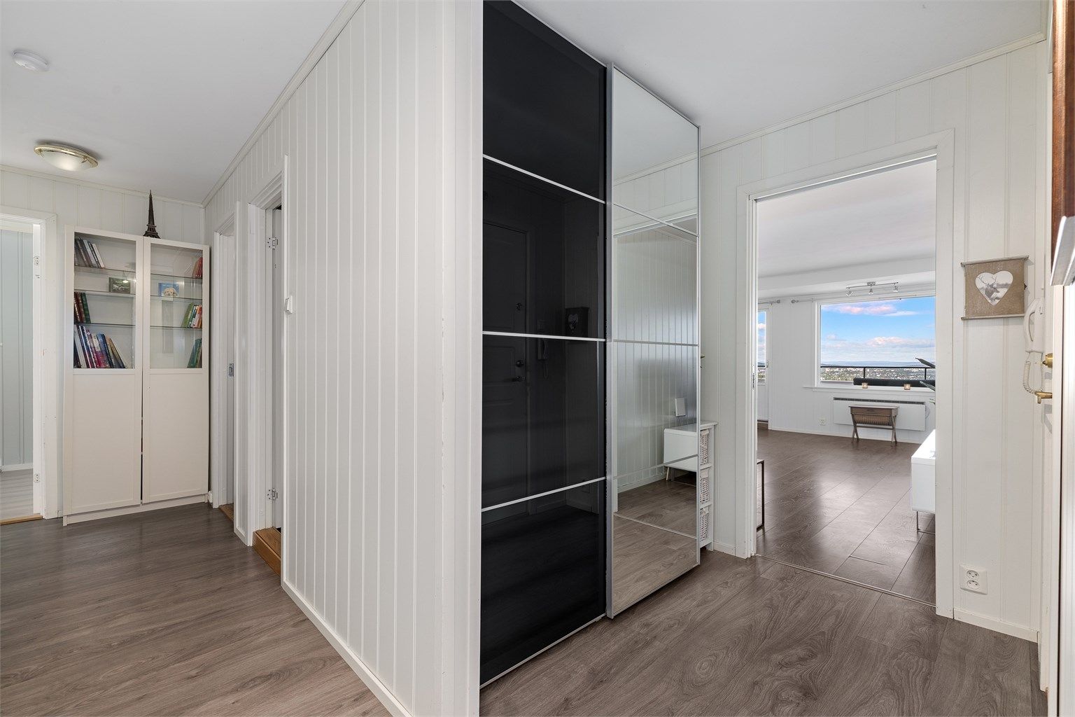 Entréen har en romslig skyvedørsgarderobe med speilfront