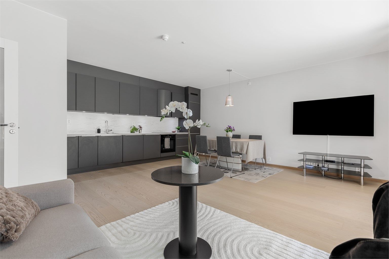 Romslig stue / spisestue med god plass til sittegruppe, TV-område og stort spisebord. Den åpne løsningen mellom kjøkken, stue og spisestue skaper en sosial atmosfære når man er med venner og familie.