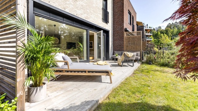 Herlig og solrik uteplass med utgang fra stuen. Markterrassen er ca 18 kvm, flott opparbeidet hage med gode solforhold. Foto: Martin Johnson (Sommerbilder) og Oh Shots (Interiørbilder og vinterbilder)