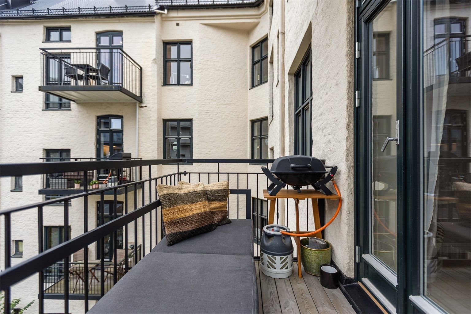 Balkongen er oppført i stålkonstruksjon med impregnerte terrassebord og plass til sittebenk.
