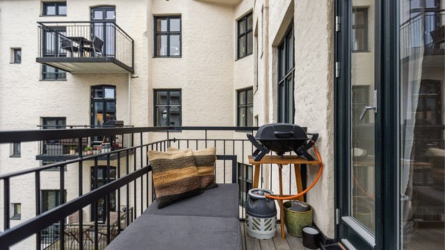 Balkongen er oppført i stålkonstruksjon med impregnerte terrassebord og plass til sittebenk.