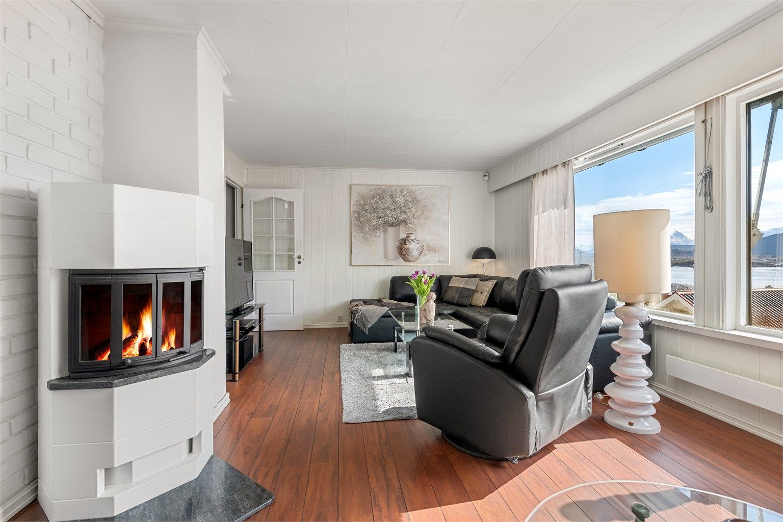 En nyere vedovn i stuen gir både god varme og en hyggelig atmosfære på kjølige dager.