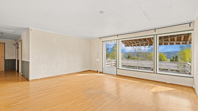 Stuen har store vinduer som slipper inn godt med lys
