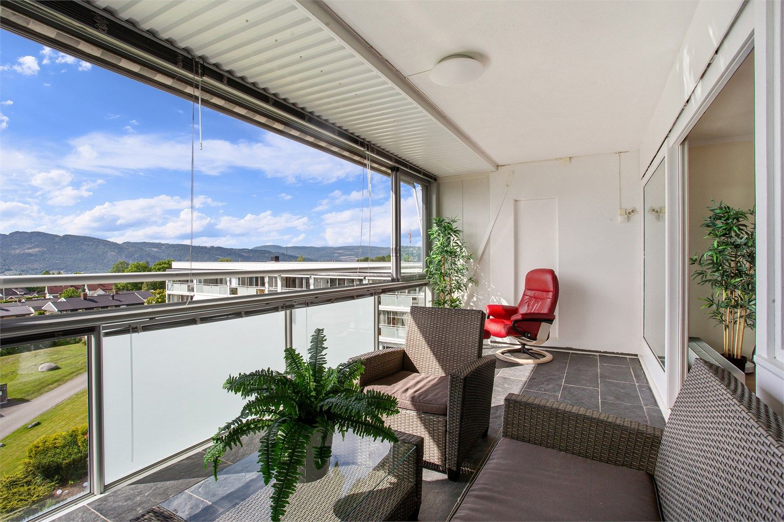 Balkong med skyvbare glassfelt, innvendig solskjerming, markise og flislagt gulv