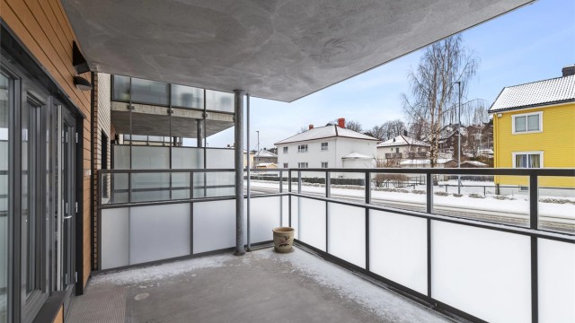 Verandaen ligger over bakkeplan med høye glassvegger, skjermet for innsyn