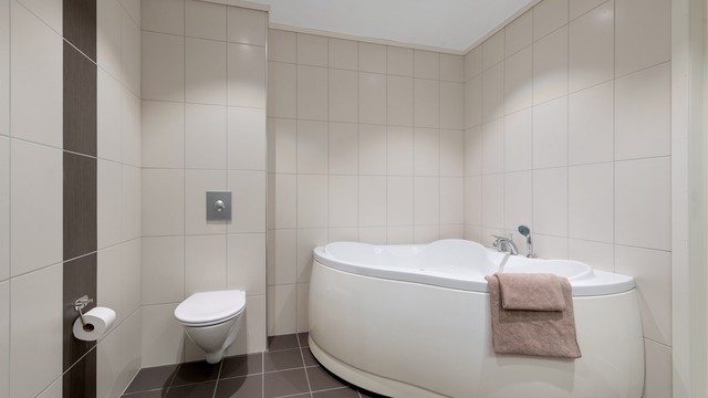 Rommet har downlights i taket, vegghengt toalett og er fra byggeåret.