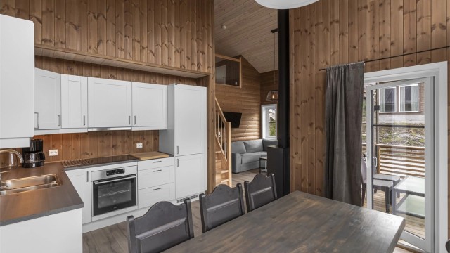 Kjøkkenet ligger delvis for seg selv med plass til spisebord. Utgang til terrasse